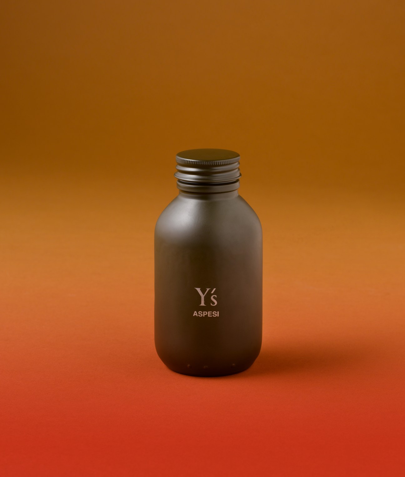 Black bottle with Y's and Aspesi branding on orange and red gradient background.