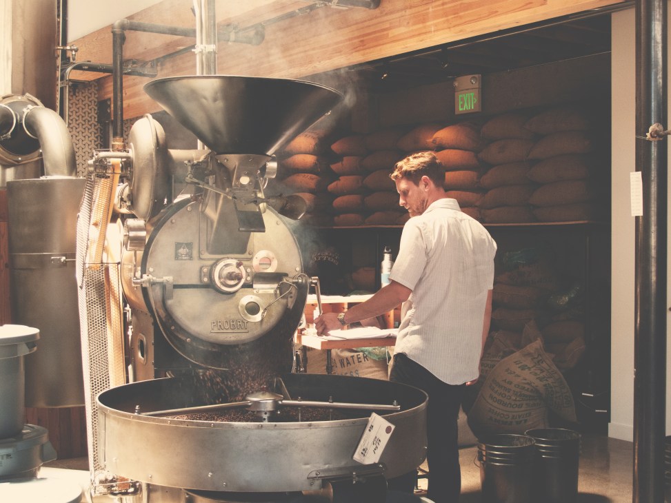Man operating a German Probat coffee roaster in Sightglass's San Francisco roastery.