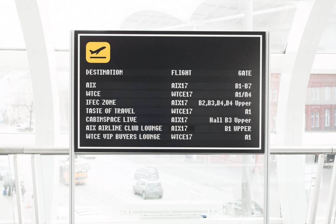 Airport-style departure board displaying event information for the Aircraft Interiors Expo in Hamburg.