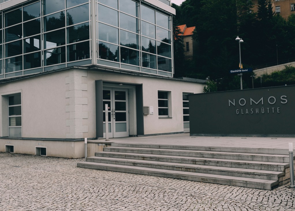 Nomos Glashütte storefront with modernist architecture and signage in Glashütte, Germany.