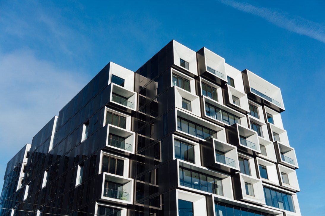 Modern black and white cube-patterned apartment building against blue sky
