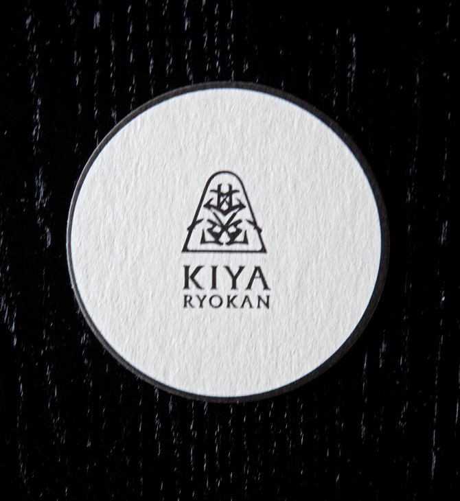 Kiya Ryokan logo featuring a geometric mountain design with Japanese characters on a white circular background.