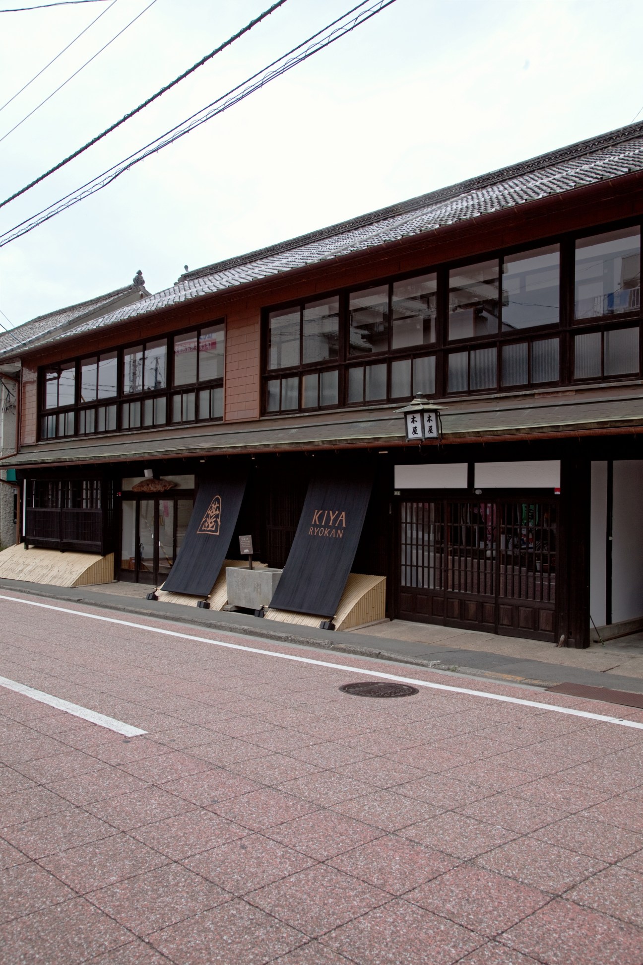 Exterior of Kiya Ryokan, a two-storey wooden building with traditional Japanese architecture and lattice windows.