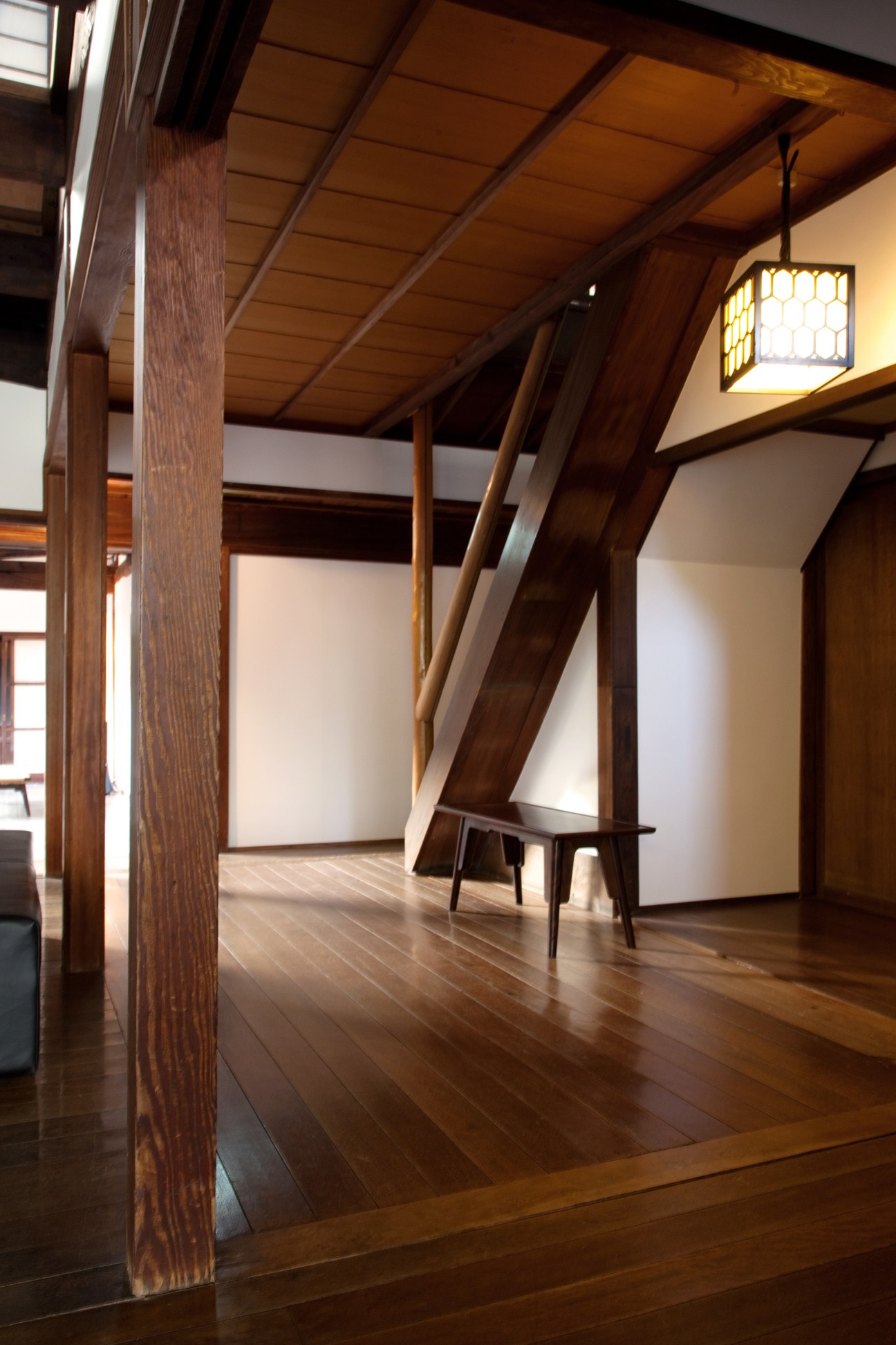 Interior of Kiya Ryokan lobby showing wooden beams, columns, and traditional Japanese architectural elements with modern lighting.
