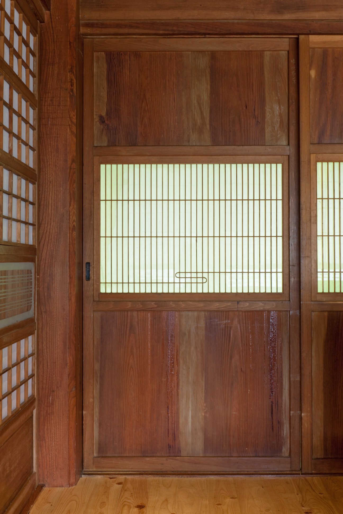Traditional Japanese wooden sliding door with frosted glass panel in the Smiles lakeside retreat.