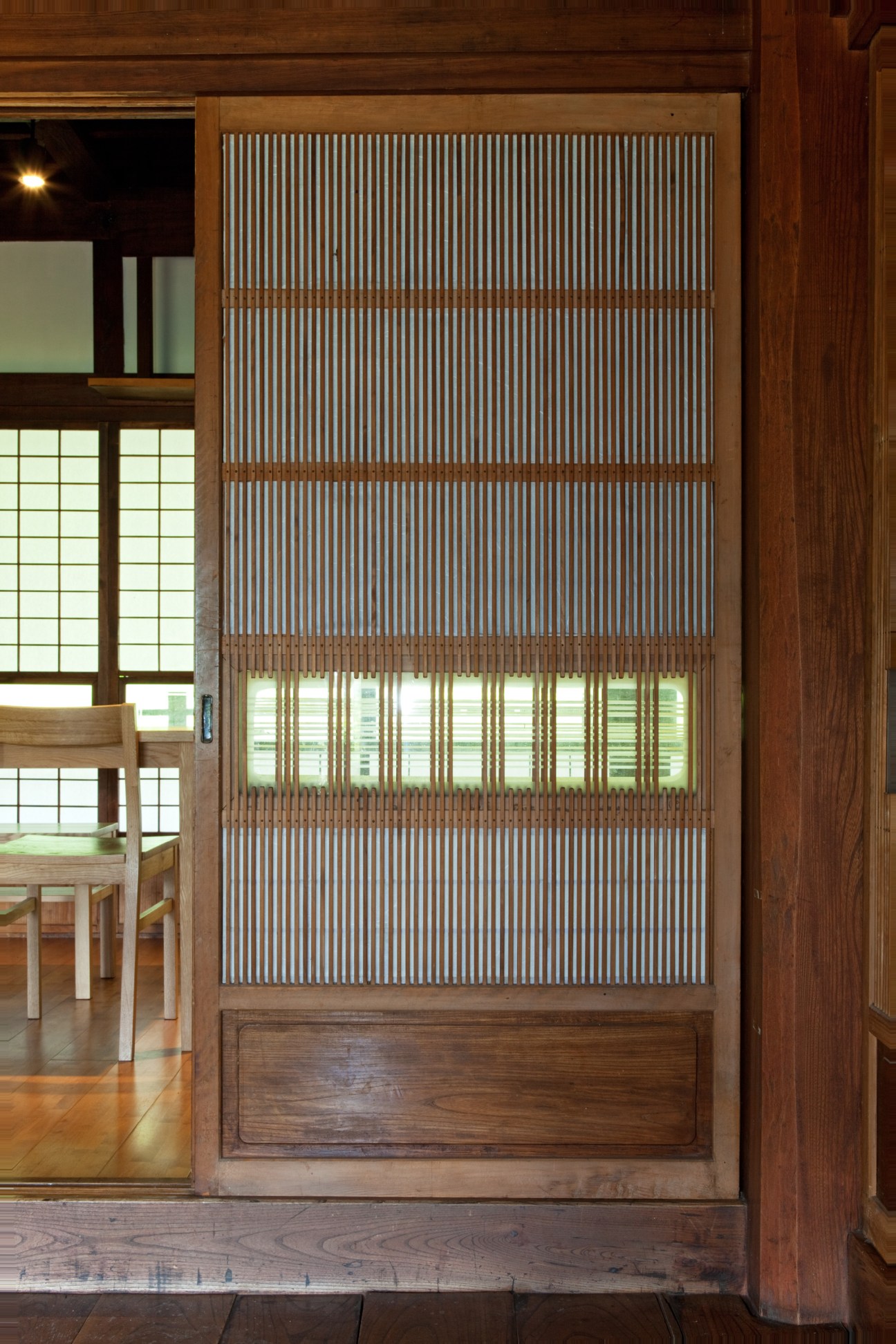 Traditional Japanese wooden sliding door with vertical slat pattern and frosted glass panels.