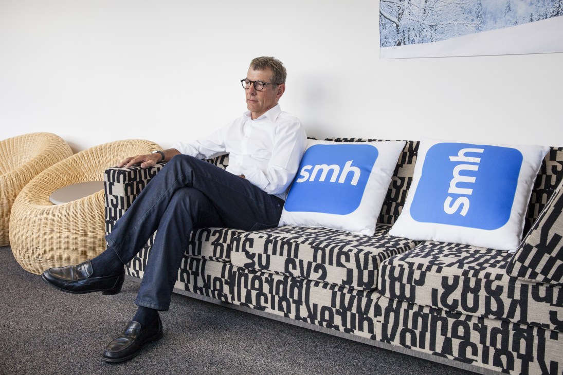 Jack Matthews, CEO of Metro Division at Fairfax Media, sitting on a sofa with SMH branding cushions in an office setting.