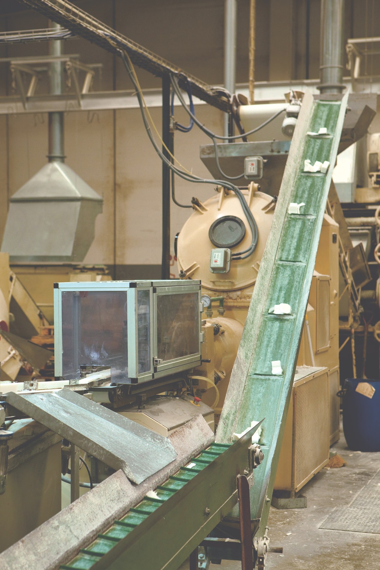 Soap bars move along a green vintage assembly line machine at Ach. Brito factory.