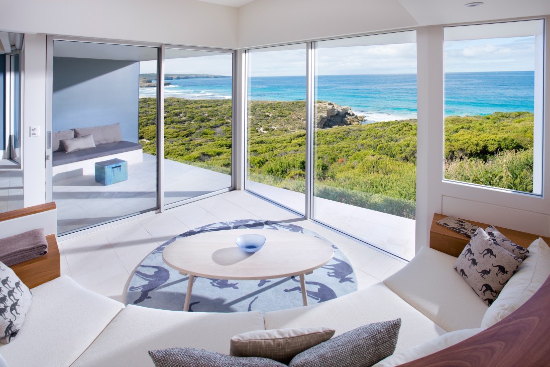 Modern suite interior at Southern Ocean Lodge with ocean views through floor-to-ceiling windows overlooking coastal landscape.