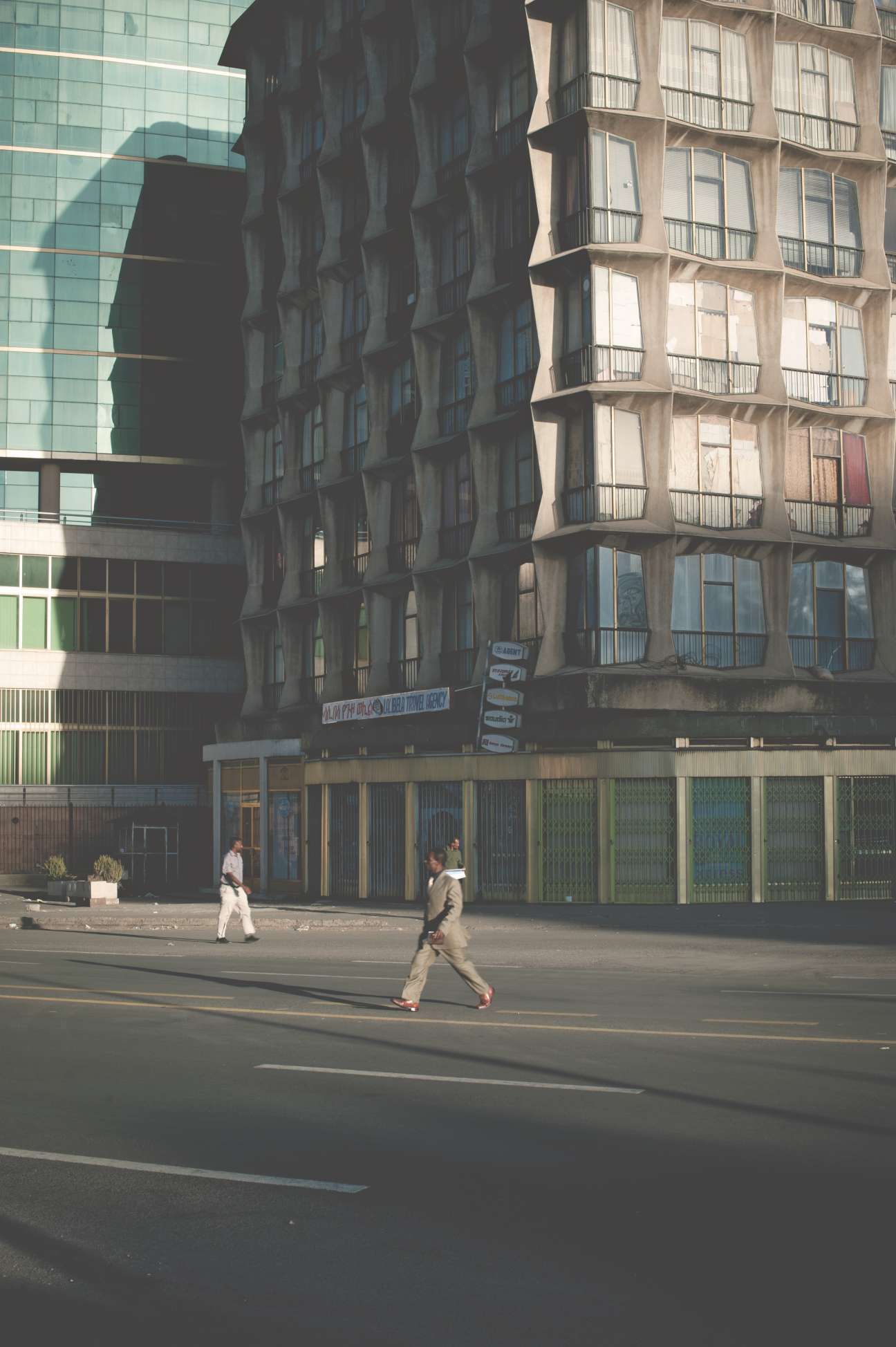 1950s-era tower block in downtown Addis Ababa with modernist architecture beside a contemporary glass building.