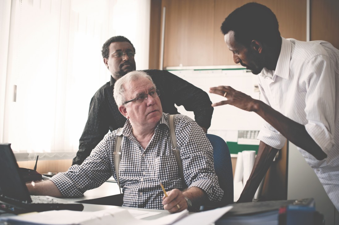 German and Ethiopian engineers discuss Peace and Security Council construction plans at a work table.