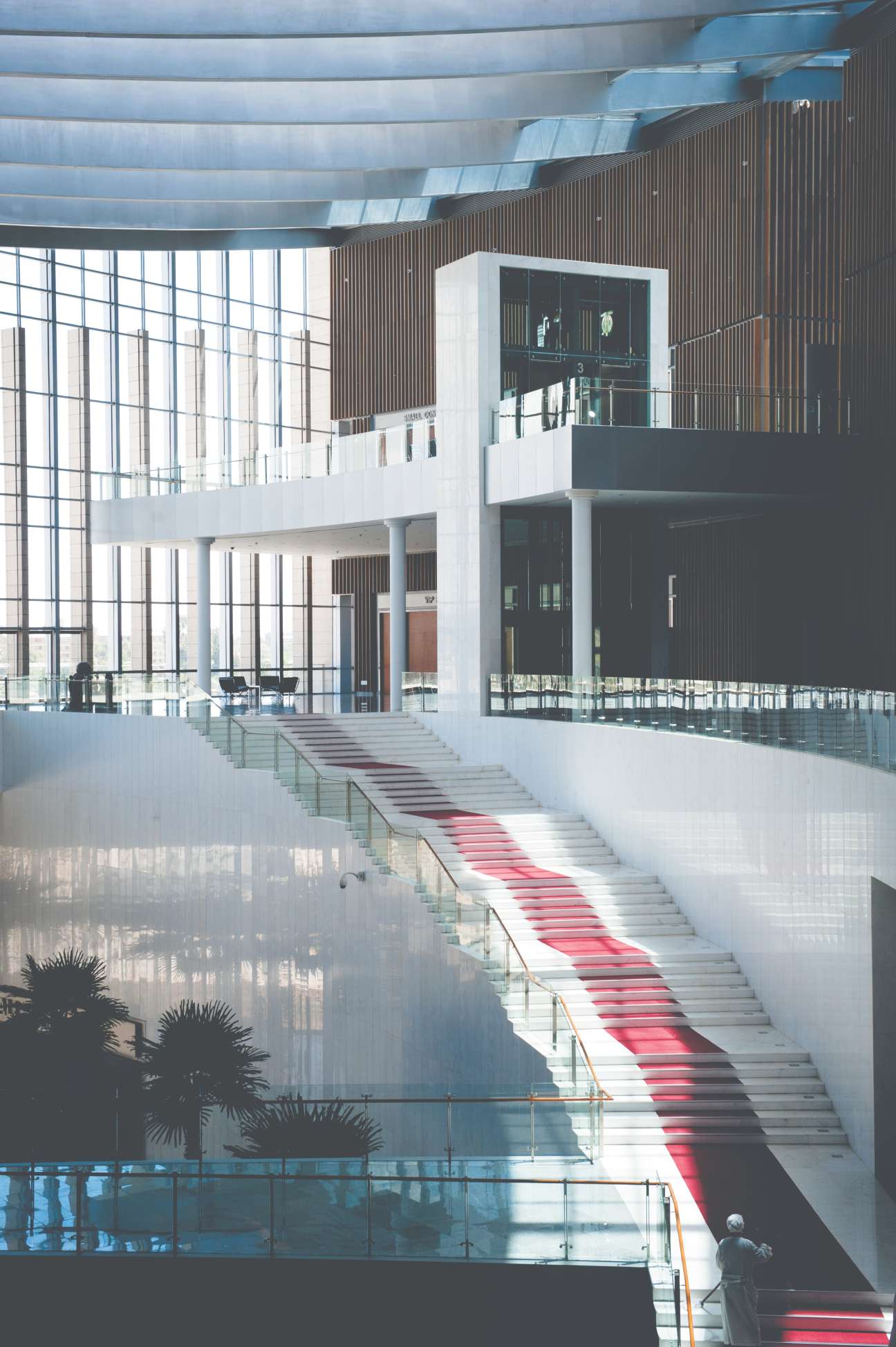 Modern interior staircase with red carpet leading upward under curved ceiling in African Union Conference Center.
