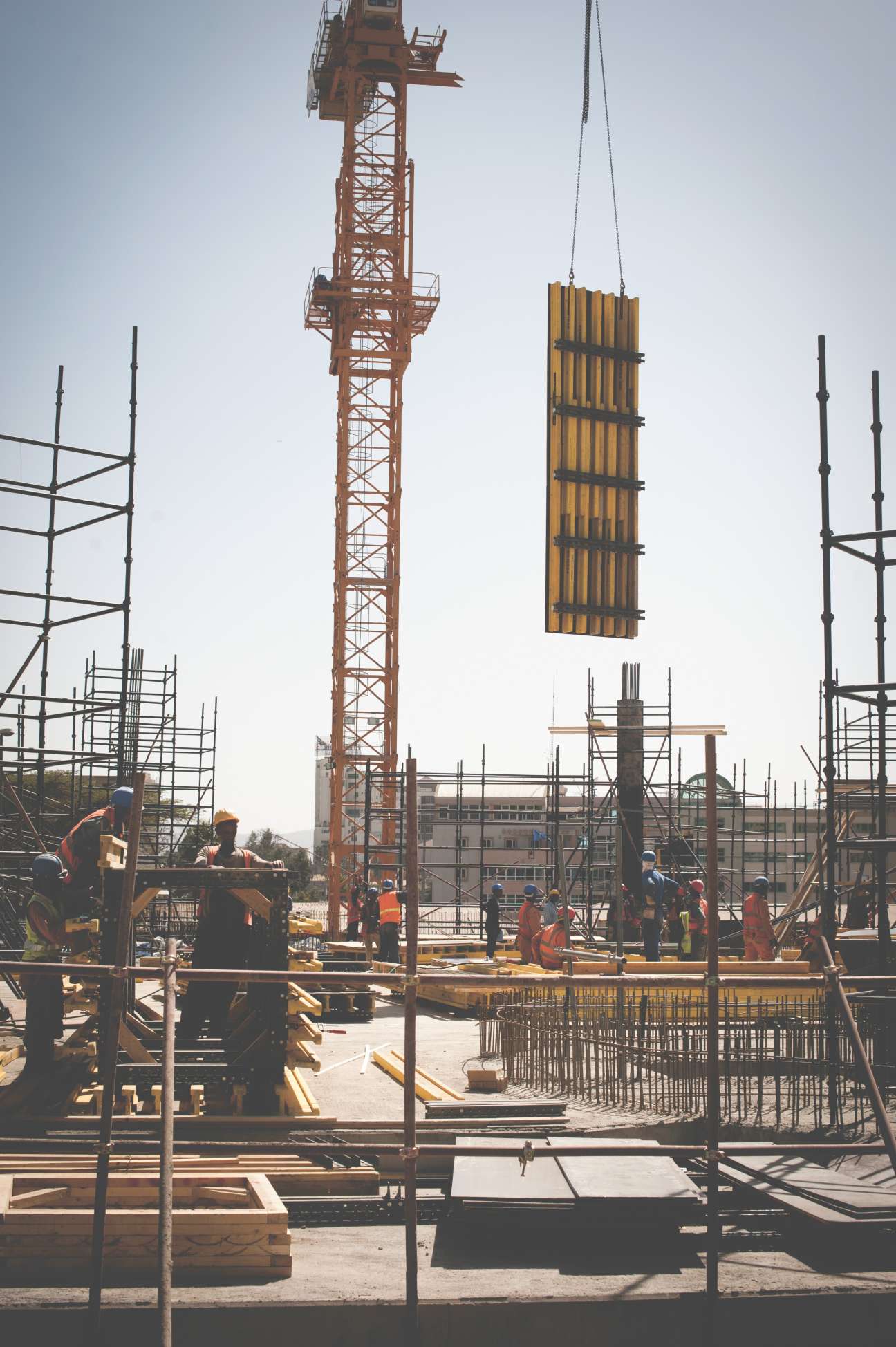Construction site with crane lifting materials, steel scaffolding, and workers building the Peace and Security Council headquarters in Addis Ababa.