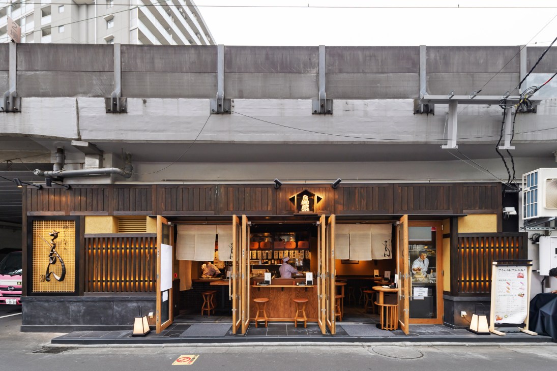 Samon Oden restaurant storefront under elevated train tracks with wooden facade and warm lighting.