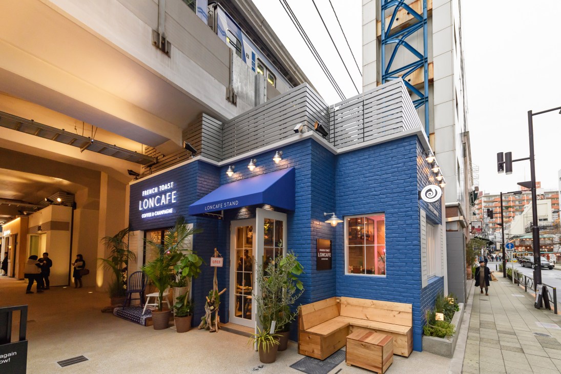 Loncafe Stand Nakameguro storefront with blue facade under train station arches in Tokyo.