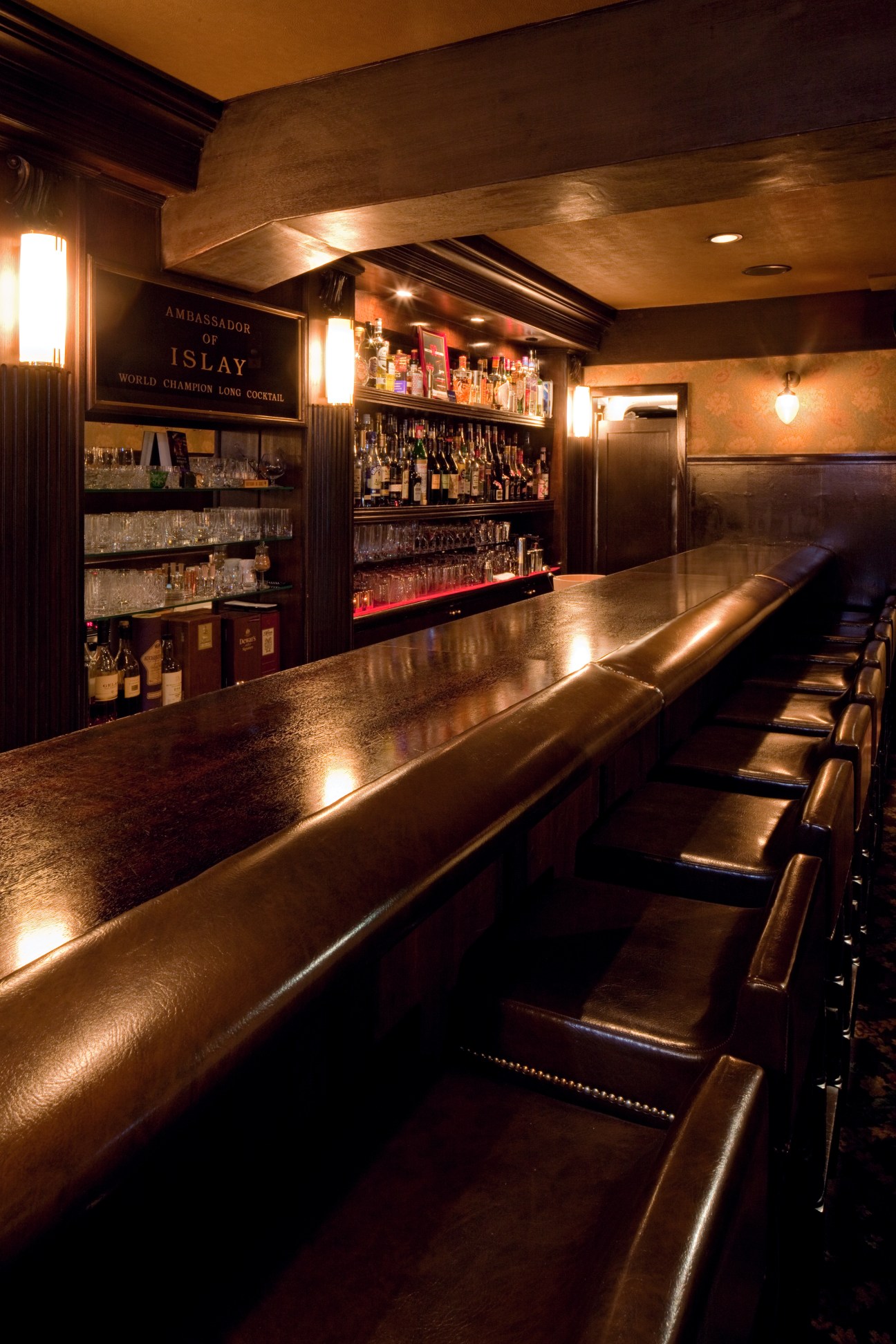 Classic Japanese bar interior with polished counter, illuminated bottle shelves, and leather seating at Star Bar Ginza.