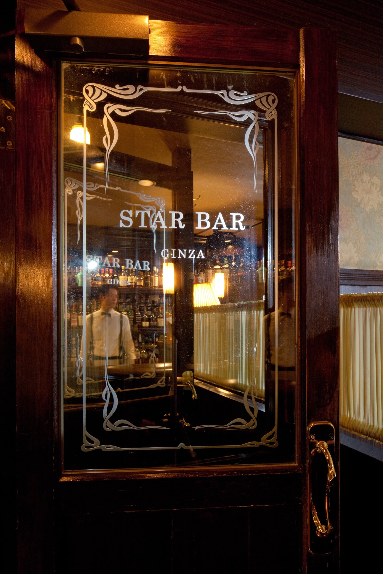 Ornate glass entrance door to Star Bar Ginza with decorative etched frame and elegant lettering