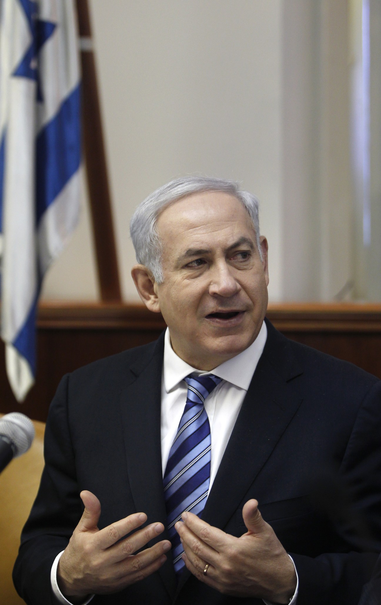 Israeli Prime Minister Benjamin Netanyahu speaking at a podium with an Israeli flag behind him.
