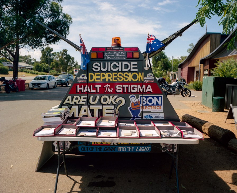 Storn Petterson's custom-built trailer displaying mental health awareness messages about suicide and depression, parked at a roadhouse.
