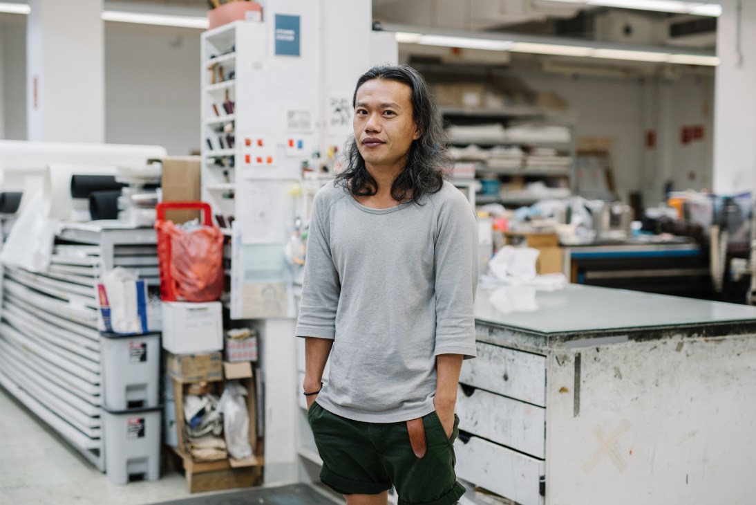 Oh Thiam Guan, senior printer at large, stands in STPI's workshop surrounded by printing equipment and supplies.