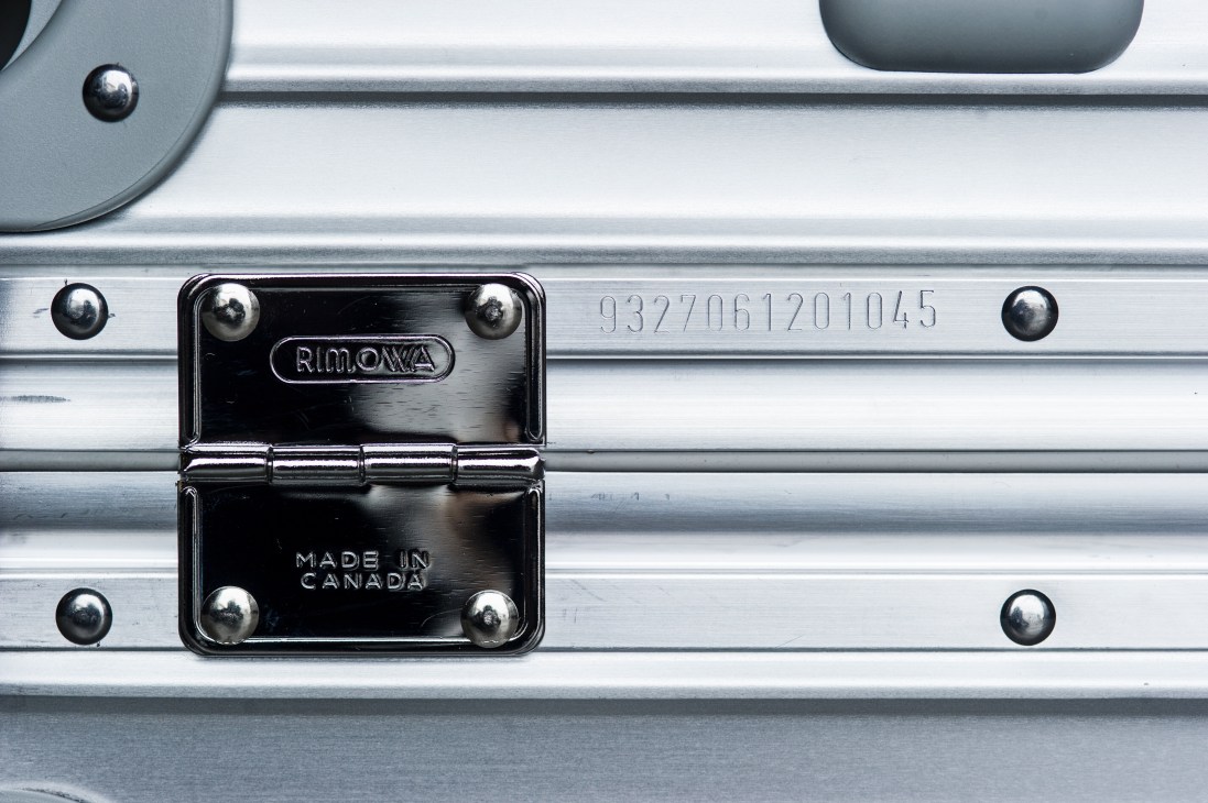 Close-up of Rimowa aluminium suitcase showing serial number and 'Made in Canada' label