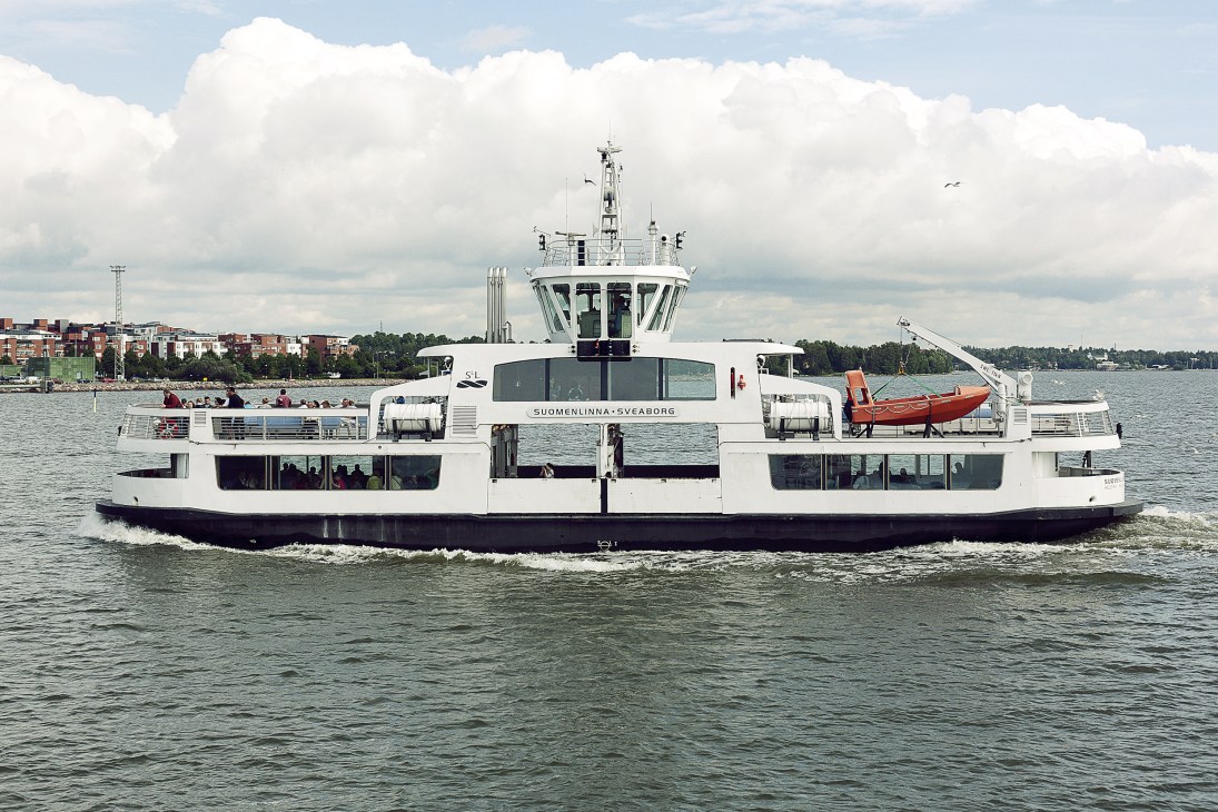 White Suomenlinna-Sveaborg ferry carrying passengers across the water to Helsinki's island fortress.