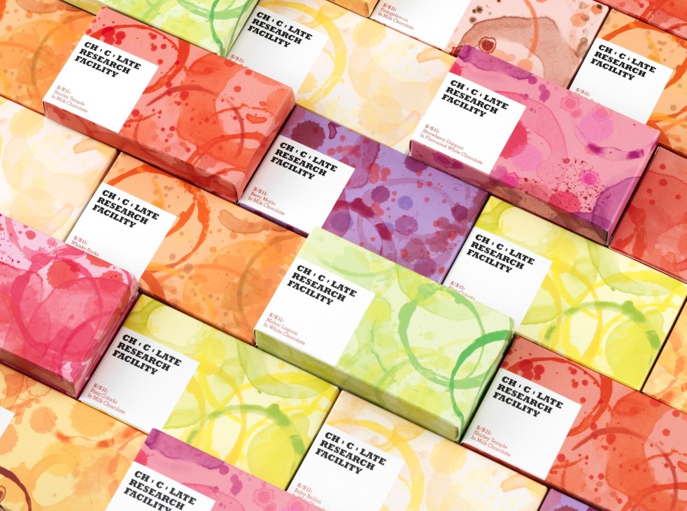 Chocolate Research Facility packaging boxes with colorful drink stain designs in pink, yellow, orange, and purple.