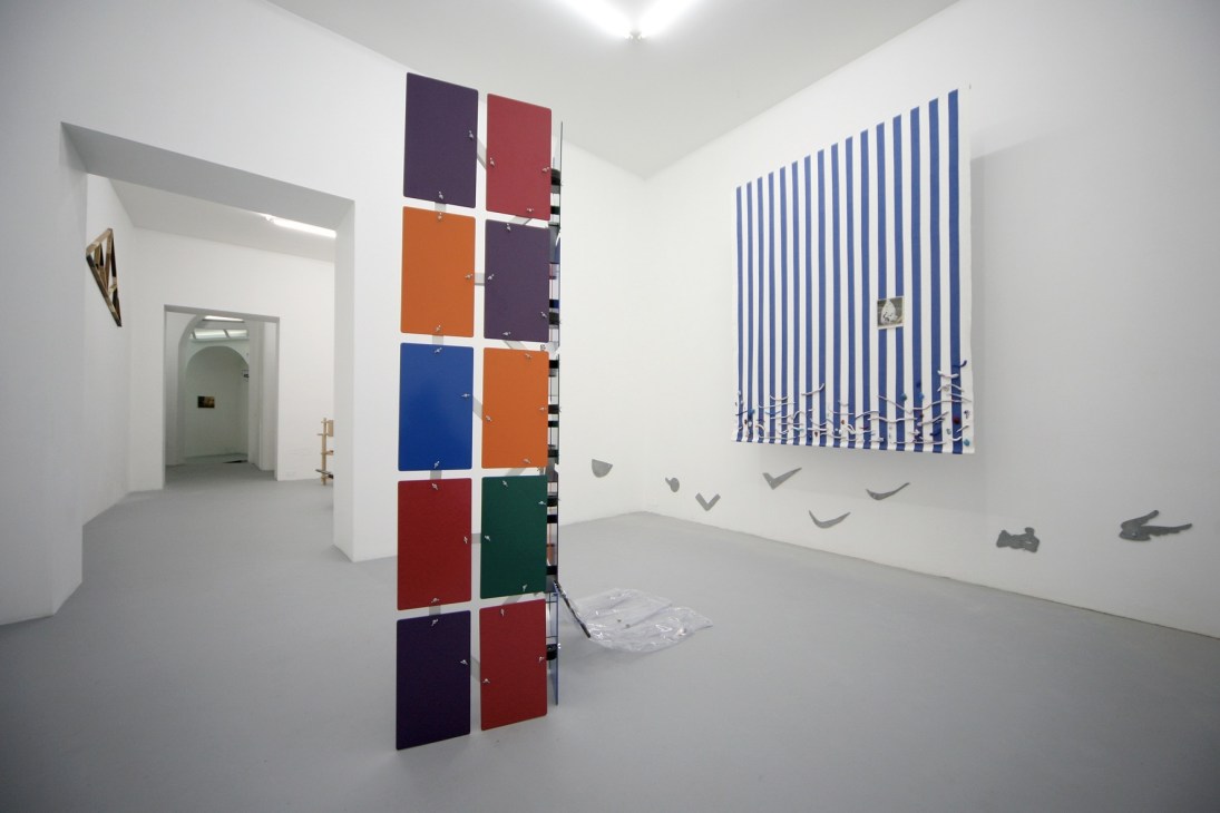 Interior of T293 gallery in Naples with colorful geometric artworks displayed on white walls.