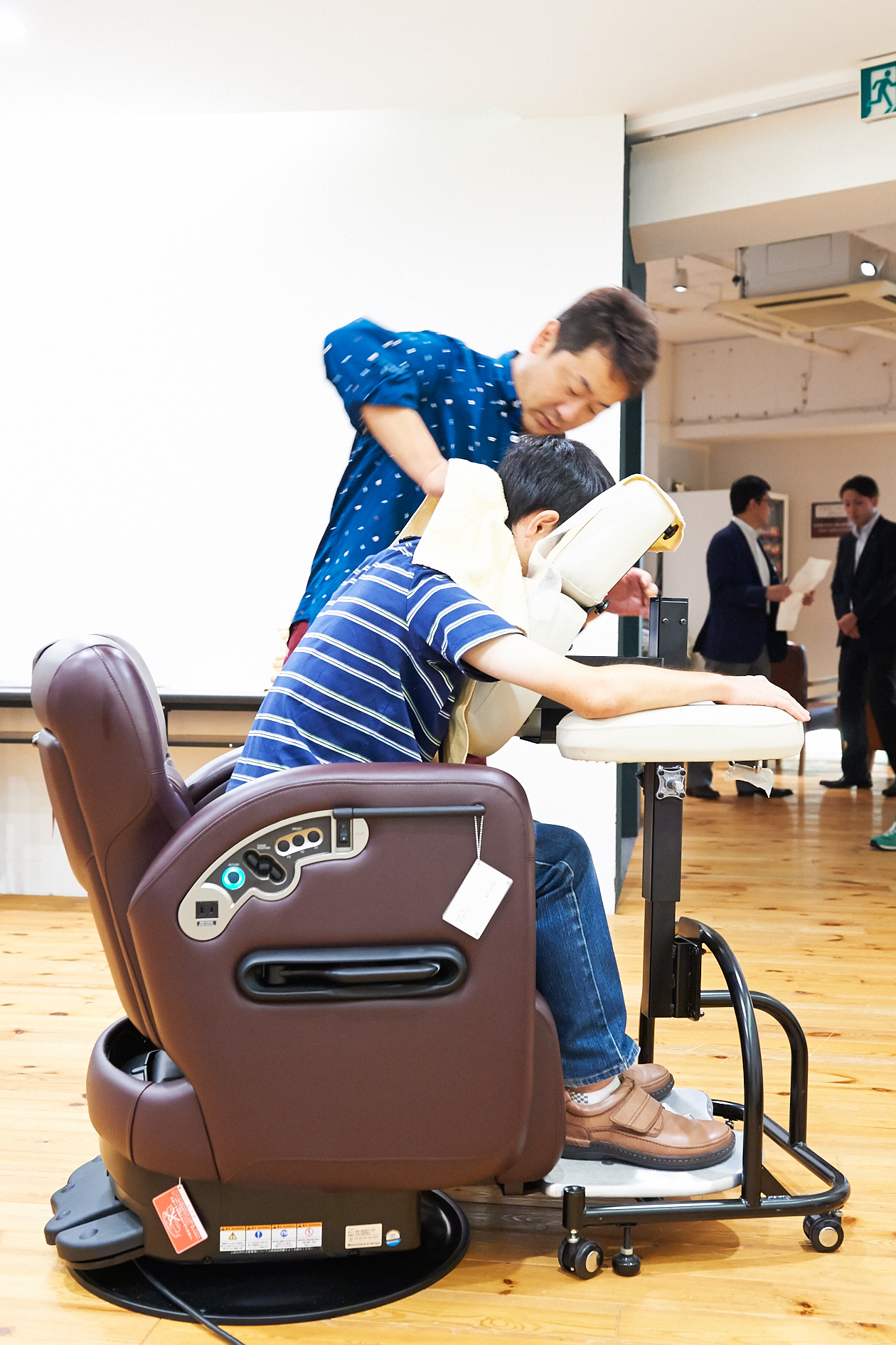 A stylist demonstrates a Takara Belmont salon chair with integrated basin at the Biyo Kaikan showroom in Tokyo.