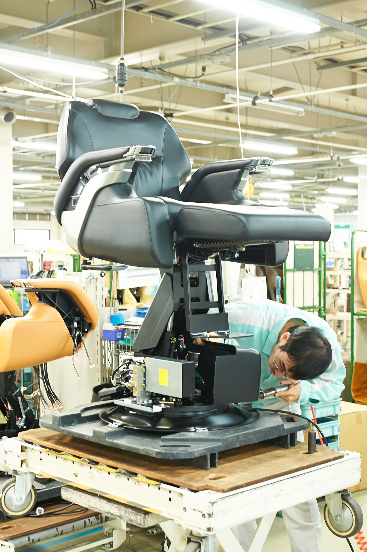 Worker inspects a Takara Belmont salon chair in factory during quality assurance.