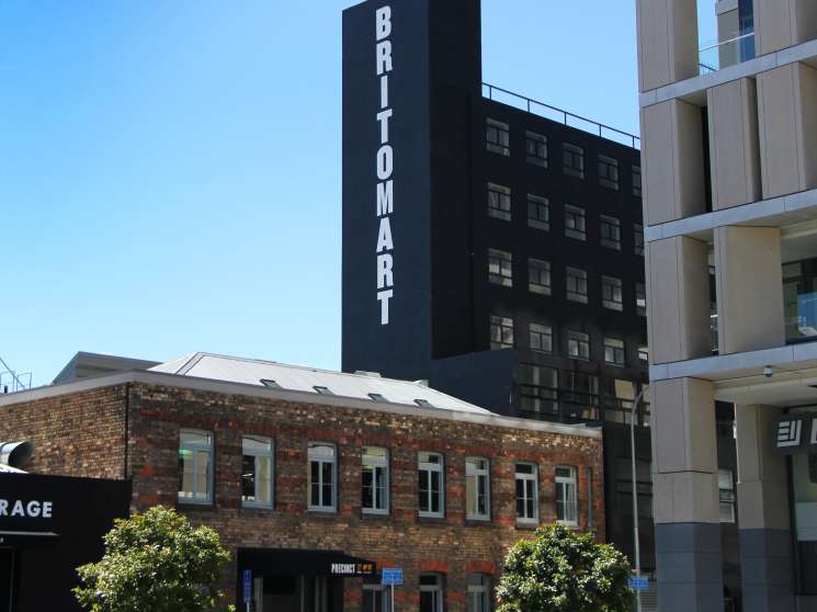 Britomart precinct in Auckland with pedestrians relaxing on red bean bags in a shared public space.