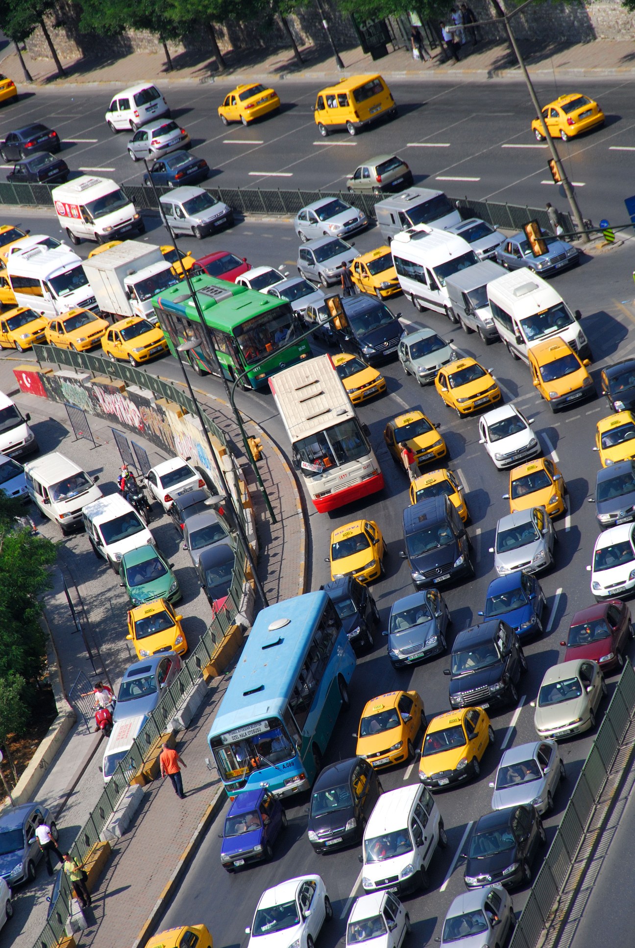 Aerial view of Istanbul street with yellow and white taxis, buses and cars in congested traffic.