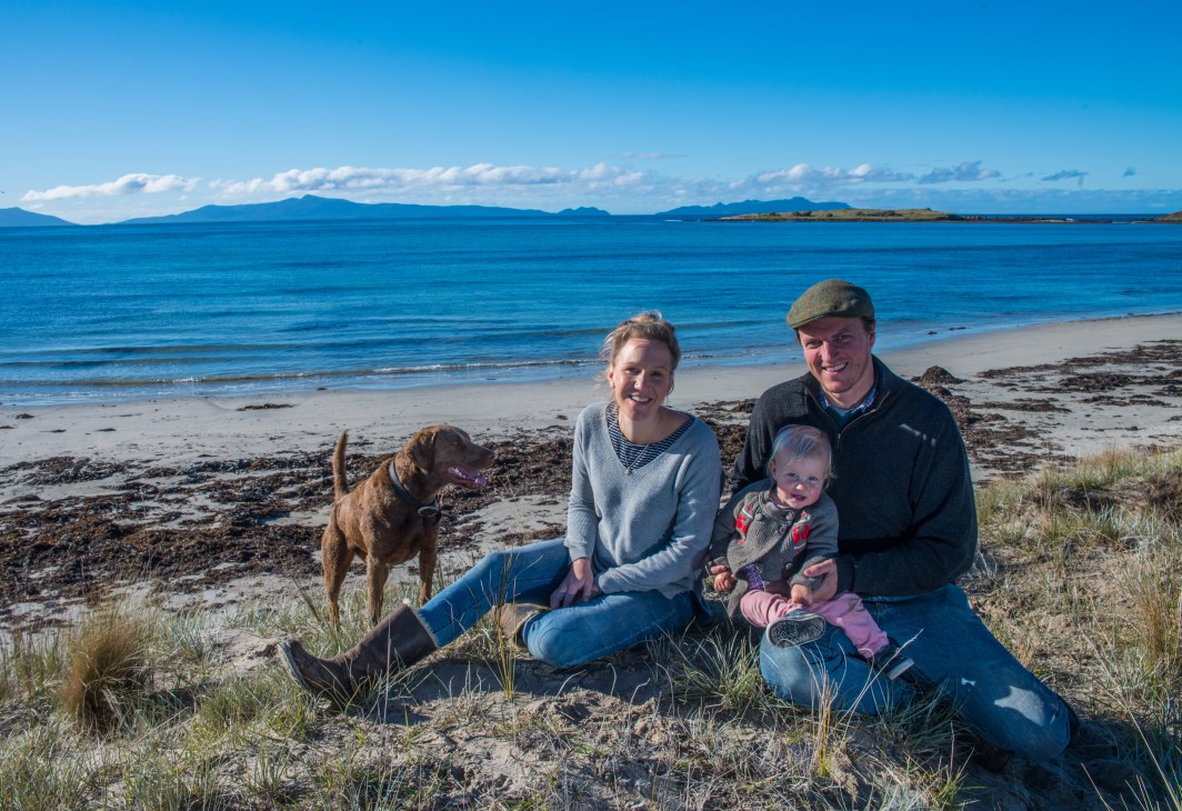 Alice Laing and Chris Manson with their daughter Flora and dog Beauly on a beach in Great Oyster Bay, Tasmania.