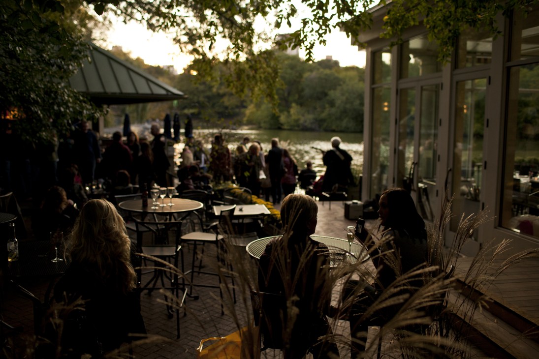 Evening scene on the terrace of Central Park Boathouse with diners at tables overlooking the lake.