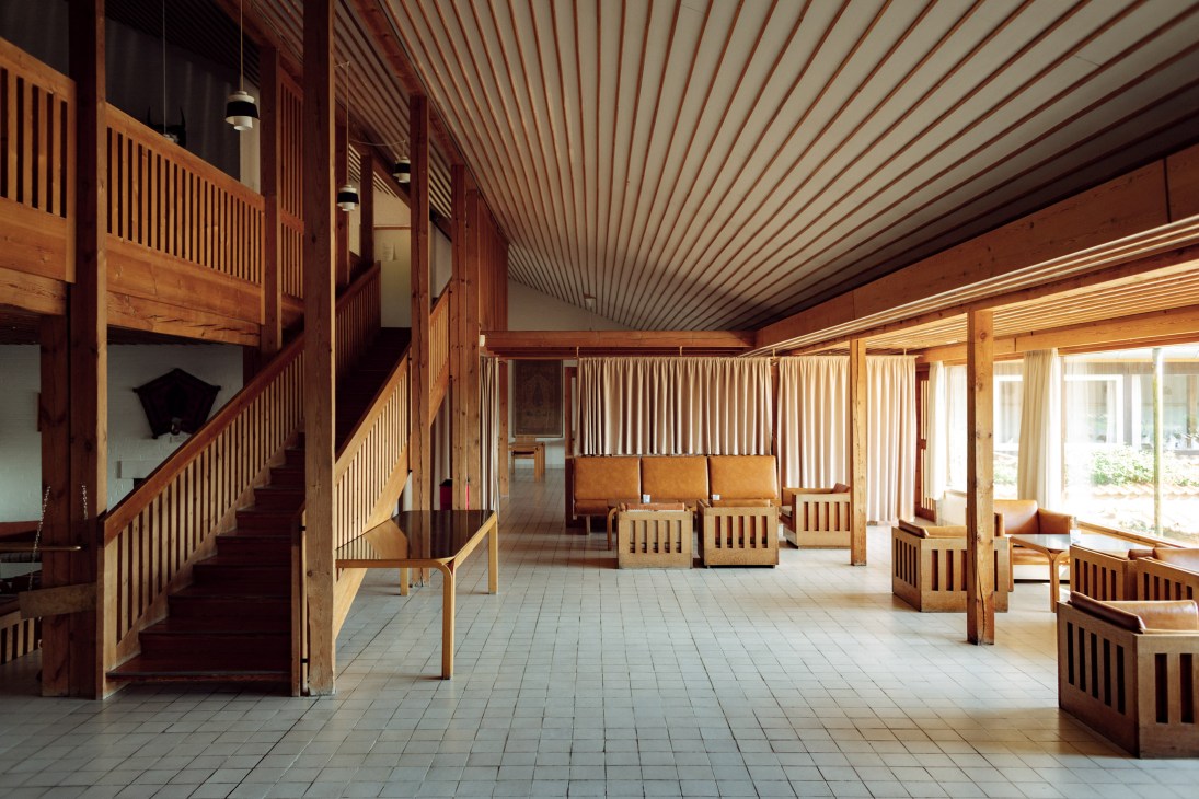 Interior of Fredensborg Houses central building with wooden furniture, railings, and striped ceiling in warm tones.