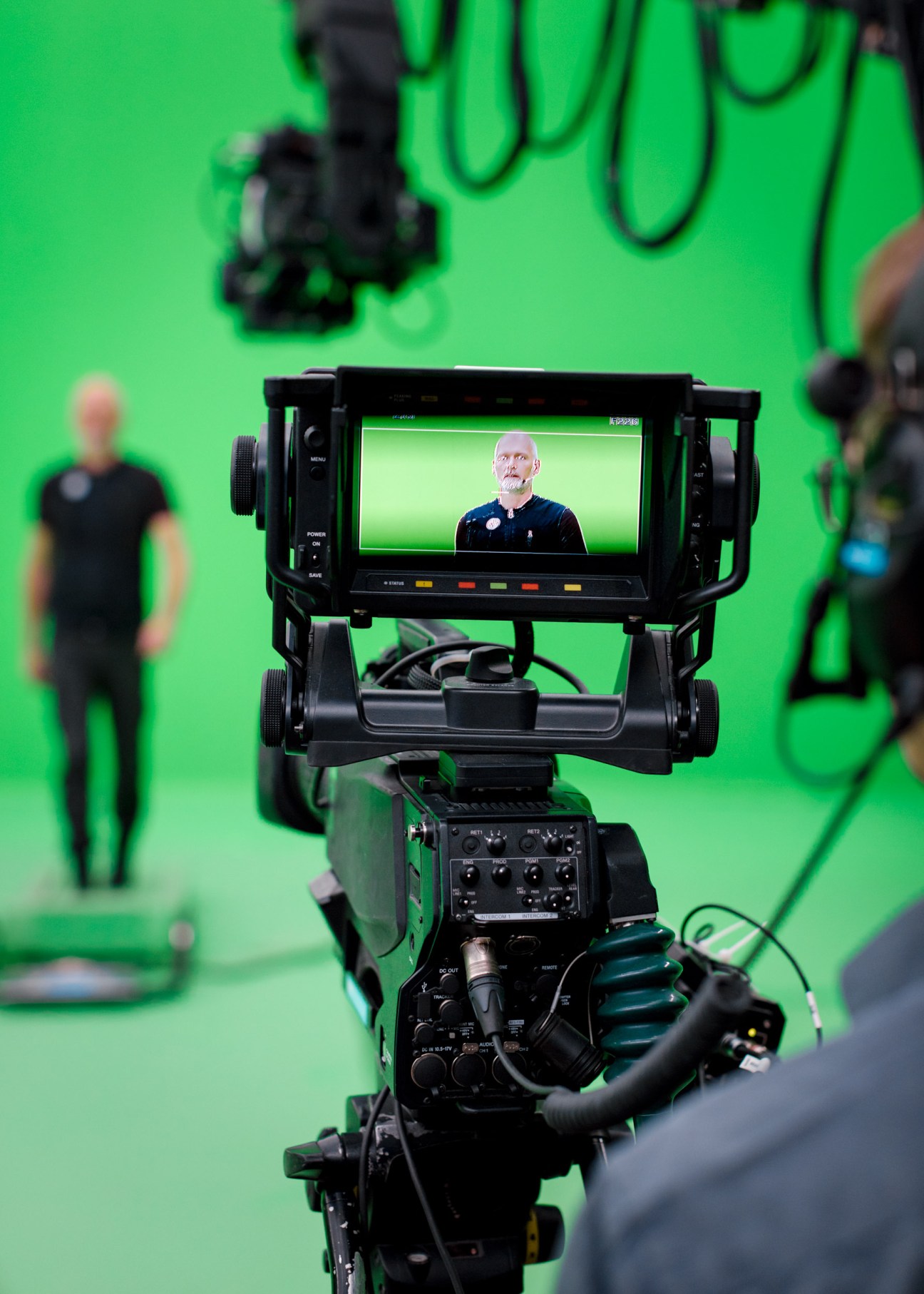 Professional camera on green screen set displaying man on monitor during live recording of Lost in Time.