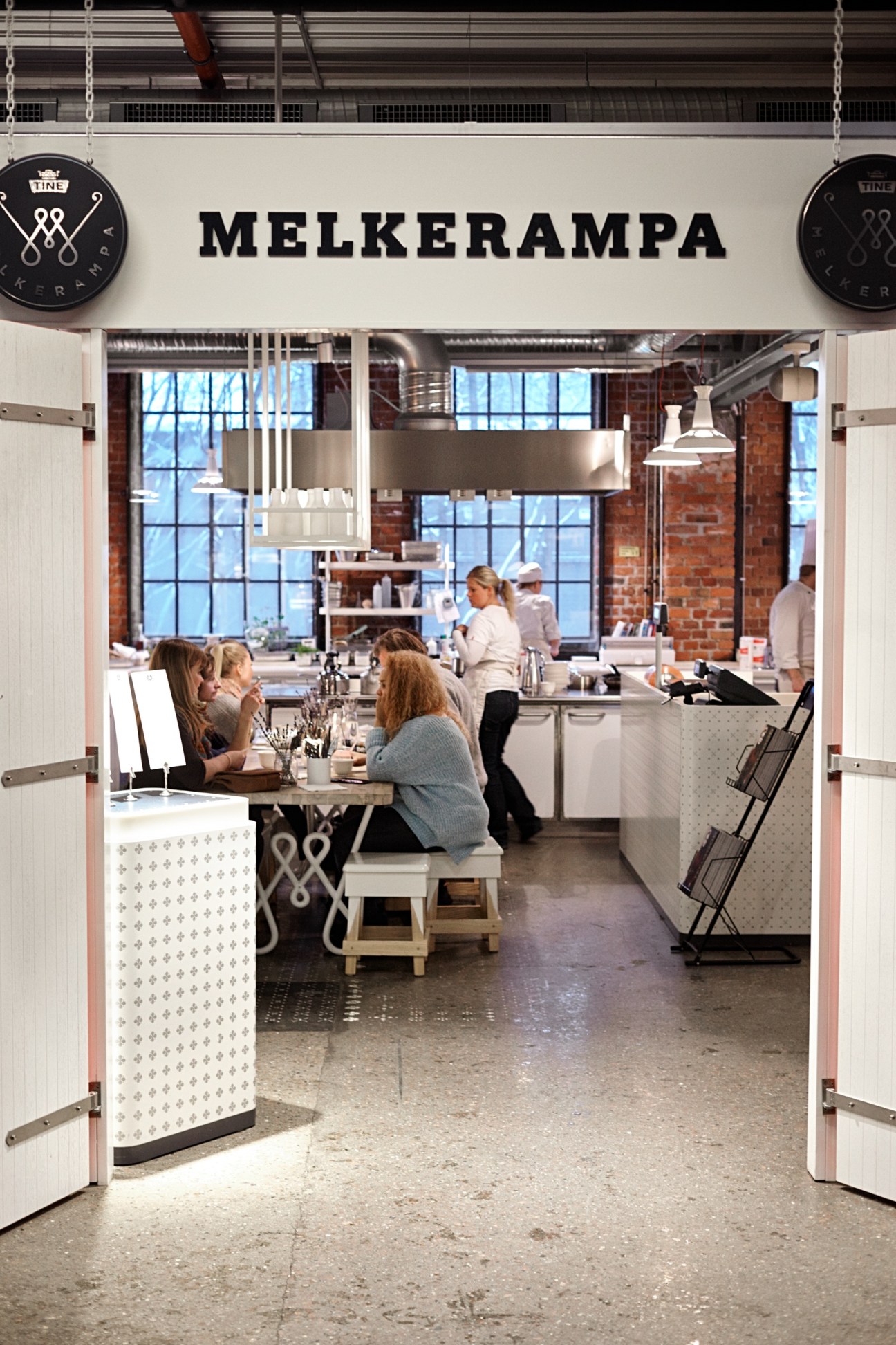 Interior of Melkerampa store at Mathallen food hall with customers and staff visible through open doors.