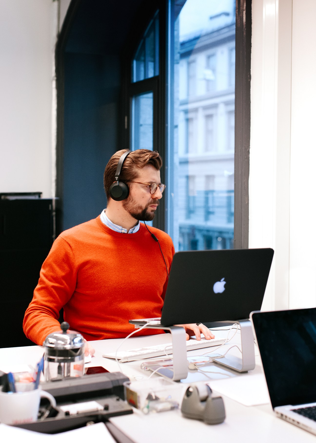 Ervin Draganovic, head of product at Tidal, wearing headphones at his desk with a laptop in the Oslo office.