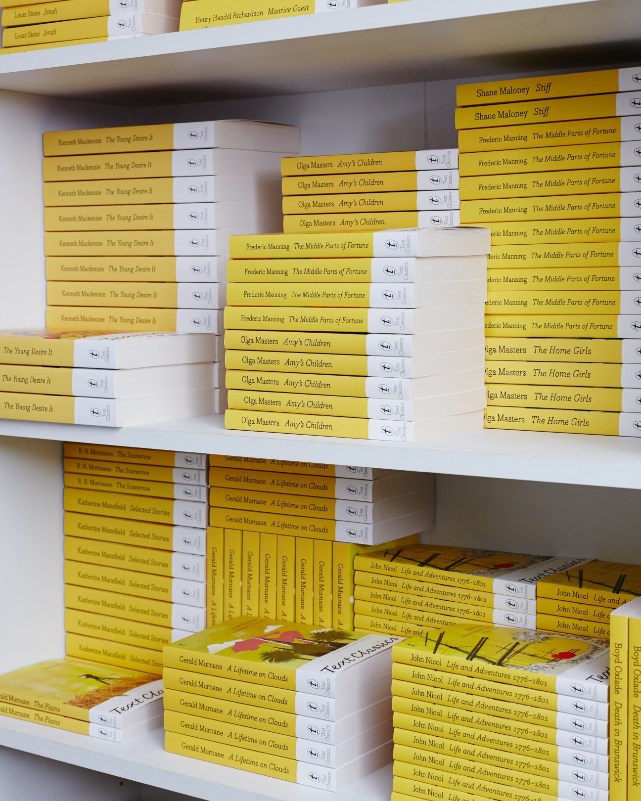 White shelving displaying yellow-spined books with white dust jackets from Text Publishing.