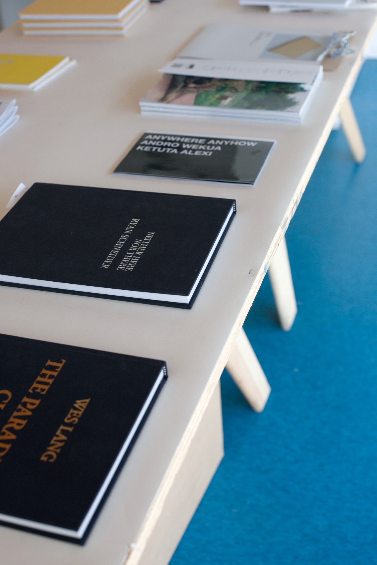 Books and publications displayed on a white table with colorful spines and covers.