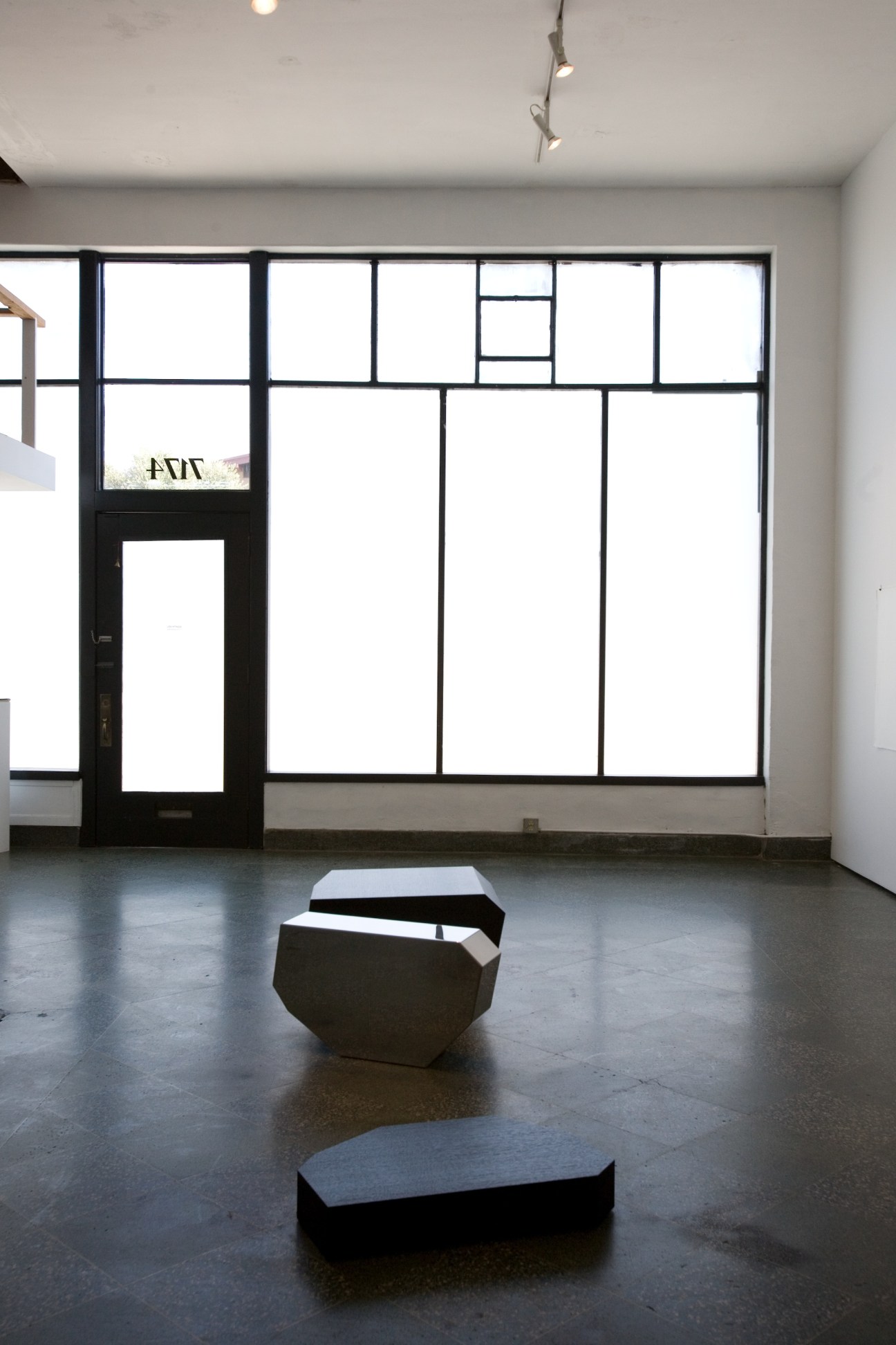 Eighth Veil gallery interior with black-framed windows and sculptural forms on polished concrete floor.