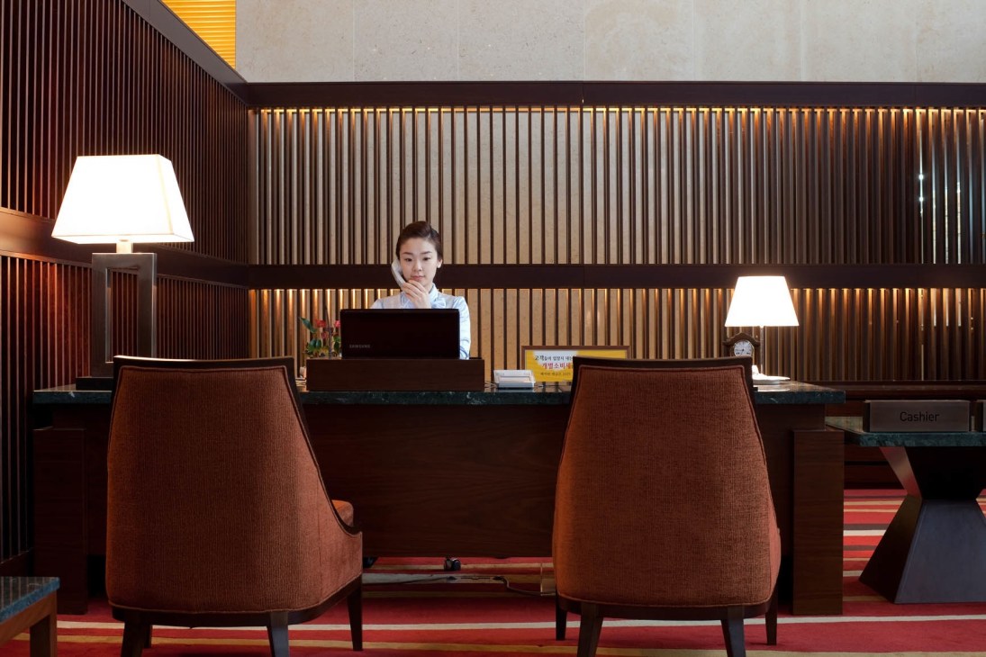 Front desk receptionist at Jack Nicklaus Golf Club Korea with modern interior design.