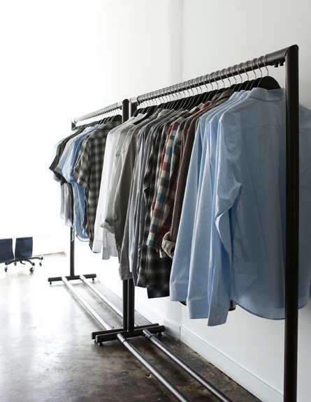 Casual menswear displayed on a black metal clothing rack at Mortar boutique.