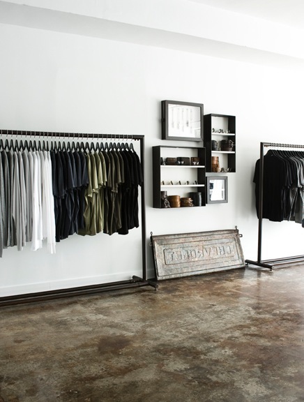Interior of Mortar menswear boutique showing clothing racks, wall shelving, and vintage sewing machine display.