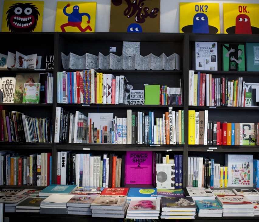 The Lazy Dog bookshop storefront displaying books, magazines, and colorful graphic artwork on shelves.