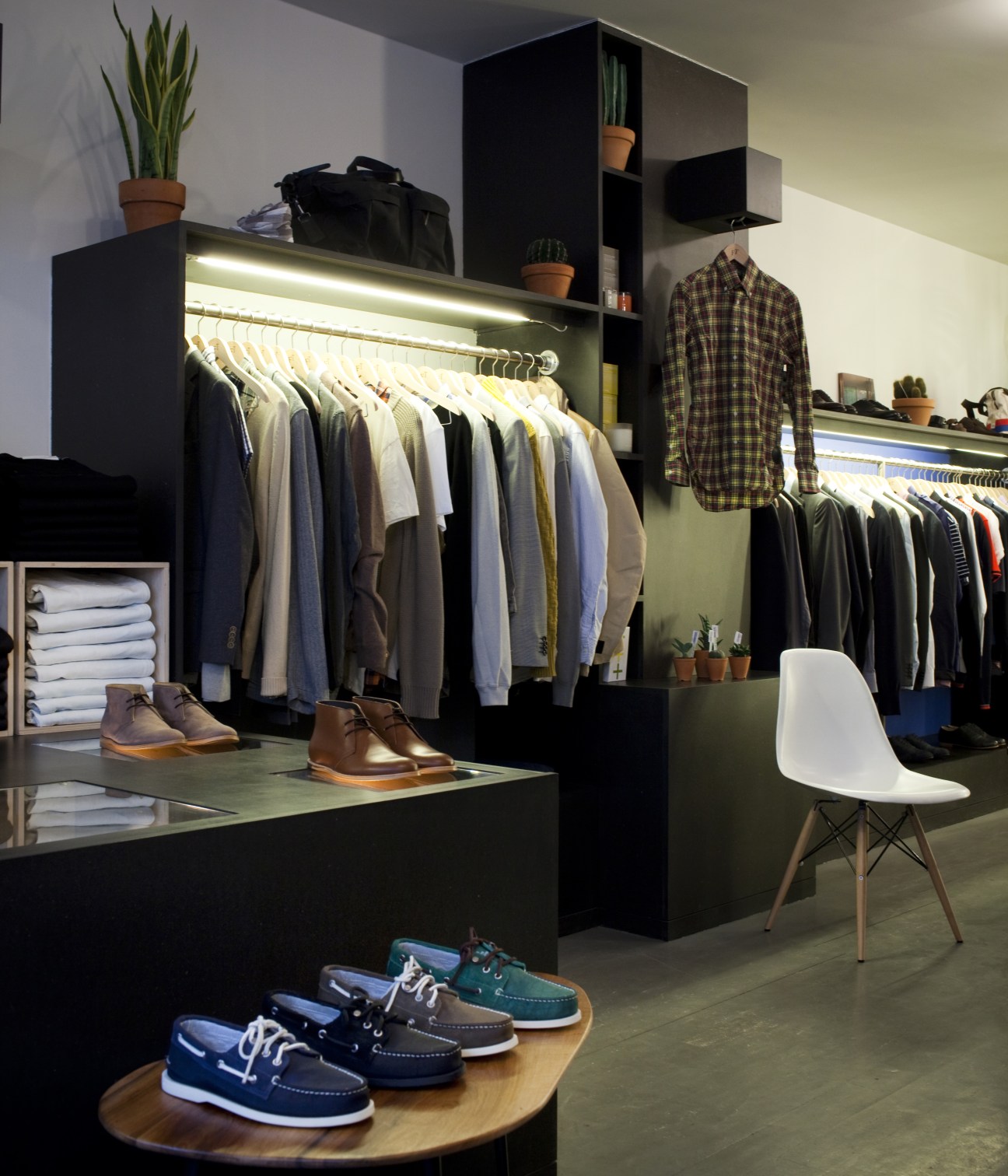 Interior of French Trotters menswear shop with clothing racks, shoes on display, and minimalist shelving.