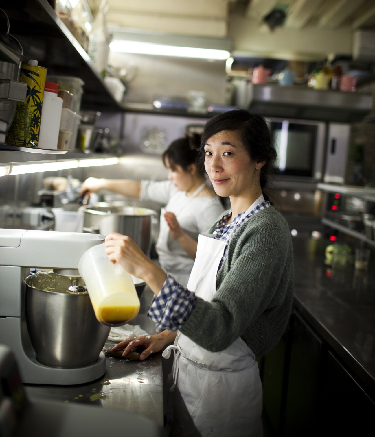 Kaori Endo, chef at Rose Bakery, pouring yellow liquid in a professional kitchen.