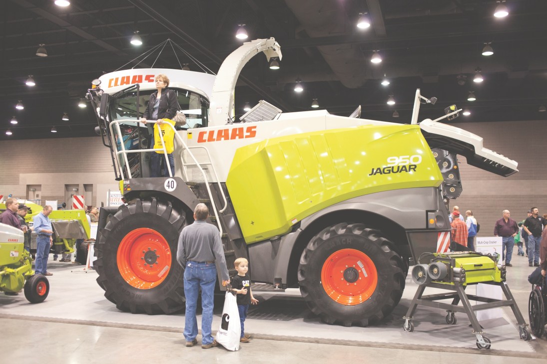 Claas 950 Jaguar forage harvester with lime-yellow and white body on display at farm machinery show.