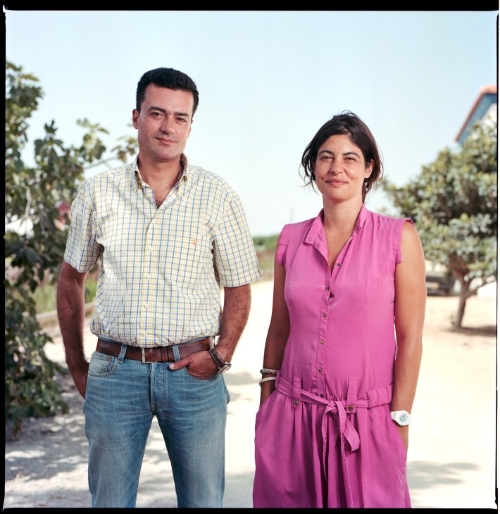 Jorge Casaleiro and Christina Bravo from Herdade da Comporta stand outdoors among trees.