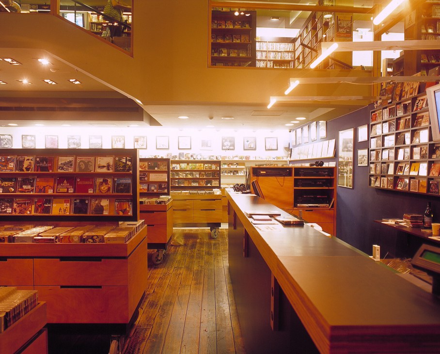 Interior of The Third Ear film and music rental store with wooden display cases and shelving.